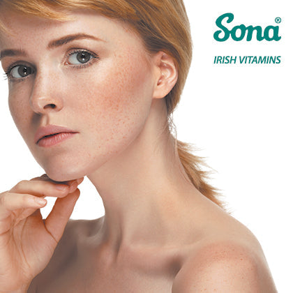 Close-up of a fair-skinned woman with clear, radiant skin, touching her face gently. Sona Irish Vitamins logo is visible in the top right corner